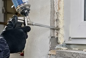 Waterproof expanding foam being applied to seal a gap